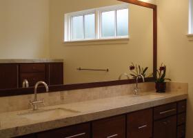 Master bath double vanity with custom wood trim around the mirror.