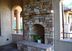 Outdoor living space featuring stone fireplace.