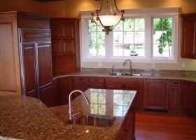 Granite counters, wood panel doors for appliances, raised bar island.