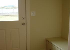 Seating and cabinetry to help with shoes, located off flush stoop concrete entrance. 